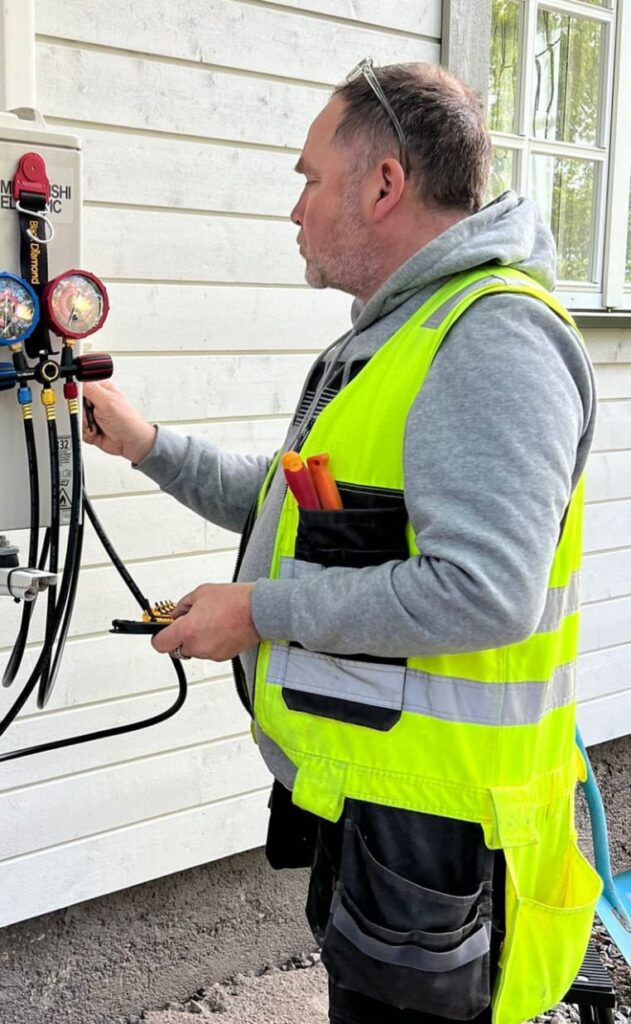 Yrityksen sähköasentaja työskentelemässä asiakkaan kodissa, suorittamassa sähkötyötä.